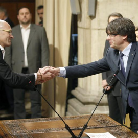El conseller de Asuntos Exteriores, Relaciones Institucionales y Transparencia, Raül Romeva, saluda al presidente de la Generalitat, Carles Puigdemont, tras tomar posesión de su cargo.- Andreu Dalmau (EFE)