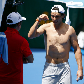 Nadal habla con su tío y entrenador, Toni Nadal, durante un entrenamiento en Melbourne Park. /REUTERS