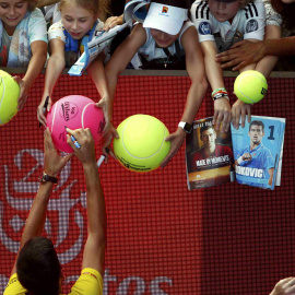 Un jugador firma autógrafos a aficionados en el Open de Australia./REUTERS