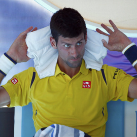 Novak Djokovic, número uno del mundo, se pone una toalla mojada para paliar el calor en su partido contra el coreano Chung en el Open de Australia. /REUTERS