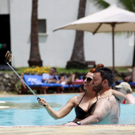 Los turistas toman una fotografía selfie dentro de una piscina en el hotel de playa Voyager en la ciudad costera de Mombasa. REUTERS