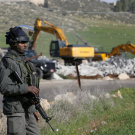 Un militar israelí monta guardia durante la demolición de una vivienda palestina en la ciudad de Dura, al sur de Hebrón. - REUTERS
