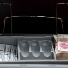 Billetes de 100 dólares y de 100 yuan en un banco de Pekín. REUTERS/Kim Kyung-Hoon