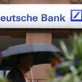 Un hombre bajo un paraguas pasa por delante de una sucursal de Deutsche Bank en la localidad alemana de Hanau. REUTERS/Kai Pfaffenbach