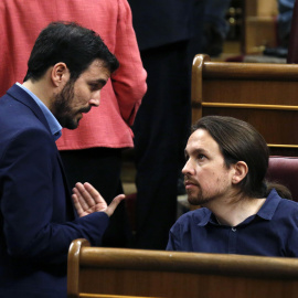 El diputado de IU-Unidad Popular, Alberto Garzón, conversa con el líder de Podemos, Pablo Iglesias, durante la sesión constitutiva del Congreso que da paso a la XI legislatura. EFE/Sergio Barrenechea
