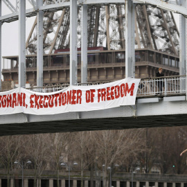 Una activista de Femen, congada de un puente de París cerca de la Torre Eiffel, para protestar contra el régimen iraní, con motivo de la visita de su presidente  Hassan Rohani. REUTERS/Charles Platiau
