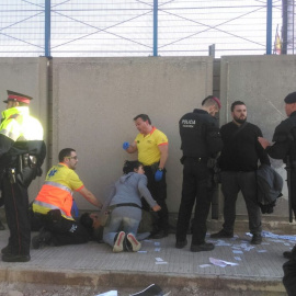 Sanitarios atienden a un herido mientras Andrés García Berrio conversa con agentes de Policía el sábado.