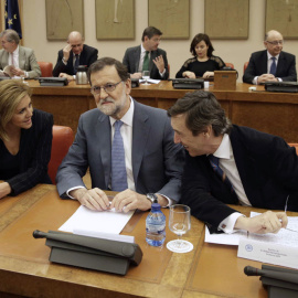 El presidente del Gobierno en funciones, Mariano Rajoy, junto a la secretaria general del PP, María Dolores de Cospedal, y el portavoz del partido en el Congreso, Rafael Hernando, durante la reunión que ha mantenido hoy con los diputados de