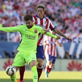 Piqué pelea por un balón con Torres.