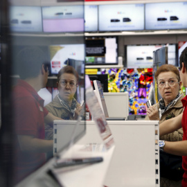 Un empleado de una cadena de productos de electrónica e infromática atiende a una clienta. REUTERS