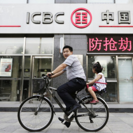 Un hombre pasa con su bicicleta por delante de una oficina del banco ICBC en Pekin. REUTERS
