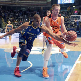 El alero dominicano del Herbalife Gran Canaria Eulis Báez (i) lucha el balón con Justin Hamilton, del Valencia Basket, durante el partido de la segundo eliminatoria de los cuartos de final de la Copa del Rey de baloncesto que se disputa hoy