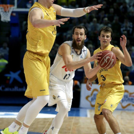 El base del Real Madrid Sergio Rodríguez (c) con el balón ante los jugadore del Herbalife Gran Canaria Alen Omic (i) y Kevin Pangos (d). EFE/Lavandeira jr