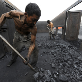 Los trabajadores trabajan con el carbón en una estación de ferrocarril en la provincia de Hefei, Anhui. REUTERS / Jianan Yu / Archivos