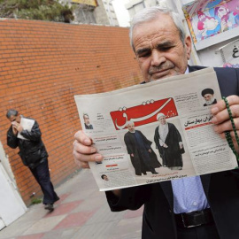 Un hombre sostiene un periódico iraní con una imagen del presidente Rohaní y del expresidente Rafsanjani bajo el título: "Decisiva victoria de los reformistas". - EFE