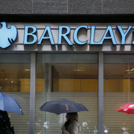Varias personas con sus paraguas pasan por delante de una oficina de Barclays en el centro de Londres. REUTERS/Stefan Wermuth