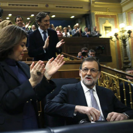 El presidente del Gobierno en funciones y líder del PP, Mariano Rajoy (d), ha sido recibido con un estruendoso aplauso por los diputados de su grupo al entrar al hemiciclo del Congreso, donde inaugura la segunda jornada del debate de invest