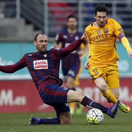 El delantero argentino del FC Barcelona Lionel Messi (d) y el defensa del Eibar Iván Ramis, durante el partido de la vigésima octava jornada de la Liga de Primera División que se juega hoy en el estadio de Ipurua, en Eibar. EFE/Javier Etxez