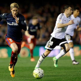 El delantero del Atlético de Madrid Fernando Torres (i) persigue el balón junto a Javi Fuego, del Valencia CF. /EFE