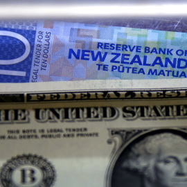 Un billete de diez dólares neozelandeses junto a un dólar estadounidense. REUTERS/David Gray