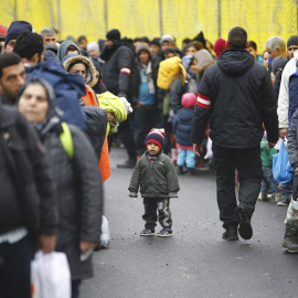 Decenas de personas esperan, cargados con sus pocos enseres, a poder cruzar la frontera de Eslovenia para llegar a Spielfeld, Austria.- REUTERS