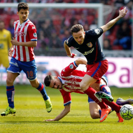 El centrocampista del Sporting Sergio Álvarez (d) y el centrocampista del Atlético de Madrid Saúl Ñíguez durante el partido de la trigésima jornada de Liga que disputan en el estadio del Molinón, en Gijón. /EFE