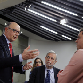 El ministro de Hacienda en funciones, Cristóbal Montoro , en presencia del secretario de Estado de Administraciones Públicas, Antonio Beteta, conversa con los periodistas al término de la rueda de prensa que ha ofrecido junto a la vicepresi