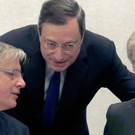 El presidente del BCE, Mario Draghi, conversa con el economista jefe de la entidad Peter Praet, en presencia del esgobrnador del Banco de Francia. REUTERS