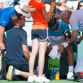 Nadal es revisado por un doctor después de retirarse de un juego contra Damir Dzumhur. - EFE