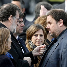 El presidente del Gobierno en funciones, Mariano Rajoy, conversa con el vicepresident y conseller de Finanzas, Oriol Junqueras, en presencia de president de la Generalitat, Carles Puigdemont, tras el acto de recuerdo de las víctimas del acc