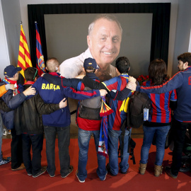 Varios aficionados barcelonistas se abrazan frente a la foto de Johan Cruyff en el memorial instalado en el Camp Nou. REUTERS/Albert Gea