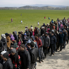 Decenas de refugiados esperan para recibir comida en las inmediaciones de Idomeni. REUTERS/Marko Djurica