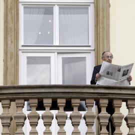 Former West German foreign minister Hans-Dietrich Genscher poses with newspapers on the balcony of the German embassy in Prague to mark the 25th anniversary of the East German exodus, in Prague in this file picture taken September 30, 2014.