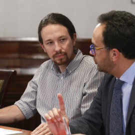 El líder de Podemos, Pablo Iglesias (i), y el portavoz socialista Antonio Hernando (d), durante la reunión que PSOE, Podemos y Ciudadanos mantienen hoy en el Congreso de los Diputados para explorar la posibilidad de negociar un acuerdo de g
