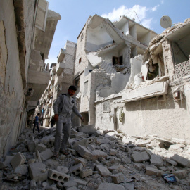 Un habitante del barrio de  al-Maysar, en Alepo, inspecciona los destrozos provocados por los bombardeos sobre las posiciones de los rebeldes sirios. REUTERS/Abdalrhman Ismail