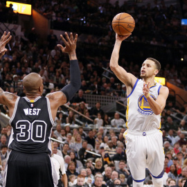 Stephen Curry, de los Warriors, lanza a canasta ante David West, de los Spurs. /REUTERS