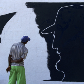 Un hombre mira un mural de Fidel Castro en las afueras de Santiago de Cuba. REUTERS