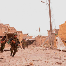 Soldados de las fuerzas de Al Asad en una de las calles de Alepo destrozadas por los bombardeos. - REUTERS