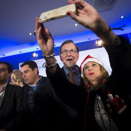 Mariano Rajoy (2d) posa para una foto junto al presidente del PP andaluz, Juanma Moreno (2i), y el presidente del PP de Córdoba y secretario de Estado de Seguridad, José Antonio Nieto (i), durante la tradicional Copa de Navidad del PP de Có