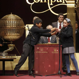 Los niños de San Ildefonso Nerea y Daniel cantan el primer cuarto premio que ha recaido en el número 59.444 del Sorteo Extraordinario de Navidad. /EFE