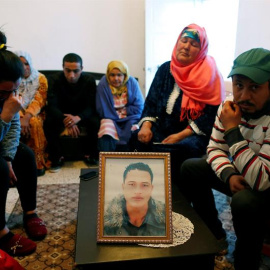 La familia de Anis Amri junto a una foto del presunto terrorista de Berlín.- EFE/Mohamed Messara