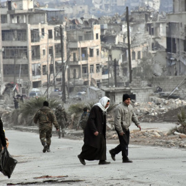 Varias personas caminan por los distritos de Zabadia y Salah Eddin en Alepo el 23 de diciembre. EFE