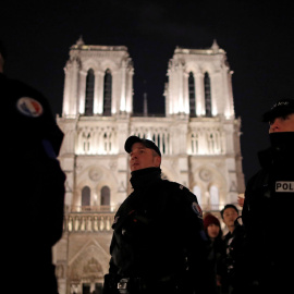 Varios agentes de la Policía francesa patrulla frente a la Catedral de  Notre-Dame, en París, la noche de Navidad. REUTERS/Christian Hartmann