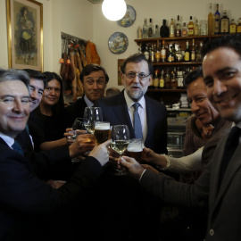 El presidente del Gobierno y del del Partido Popular, Mariano Rajoy,  acompañado de varios diputados de su formación en un bar proximo al Congreso de los Diputados tras la reunión que el grupo parlamentario popular ha celebrado en el cámara