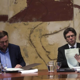 El president de la Generalitat, Carles Puigdemont (d), y el vicerpresidente del Govern y conseller de Economía, Oriol Junqueras (i), durante la última reunión ordinaria del año del ejecutivo catalán. /EFE