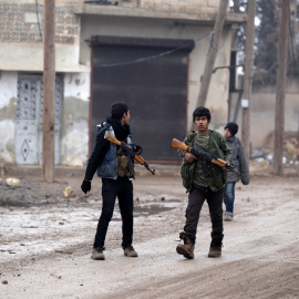 Unos jóvenes portan armas cerca de la ciudad de Alepo el día de Navidad. /REUTERS