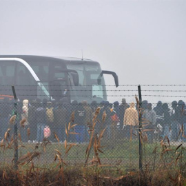 Un grupo de inmigrantes se dispone a subir a un autobús antes de abandonar un centro de acogida en la localidad de Cona, en Venecia, para ser trasladados a la región de Emilia-Romaña tras la protesta de anoche por la muerte de Sandrine Baka