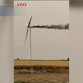 Los bomberos tratan de apagar desde un helicóptero un incendio en un aerogenerador en Pujalt (Barcelona)