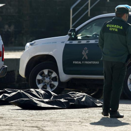 Agentes de la Guardia Civil y de Cruz Roja en el puerto de Algeciras, con uno de los cinco cadáveres de inmigrantes que han sido encontrados en las últimas horas en las costas de Algeciras y Tarifa. Los cuerpos fueron hallados en dos lugare