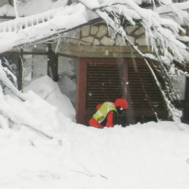 Un miembro del equipo de rescate alpino y espeleológico del Lacio se ve delante del Hotel Rigopiano en Farindola/ REUTERS